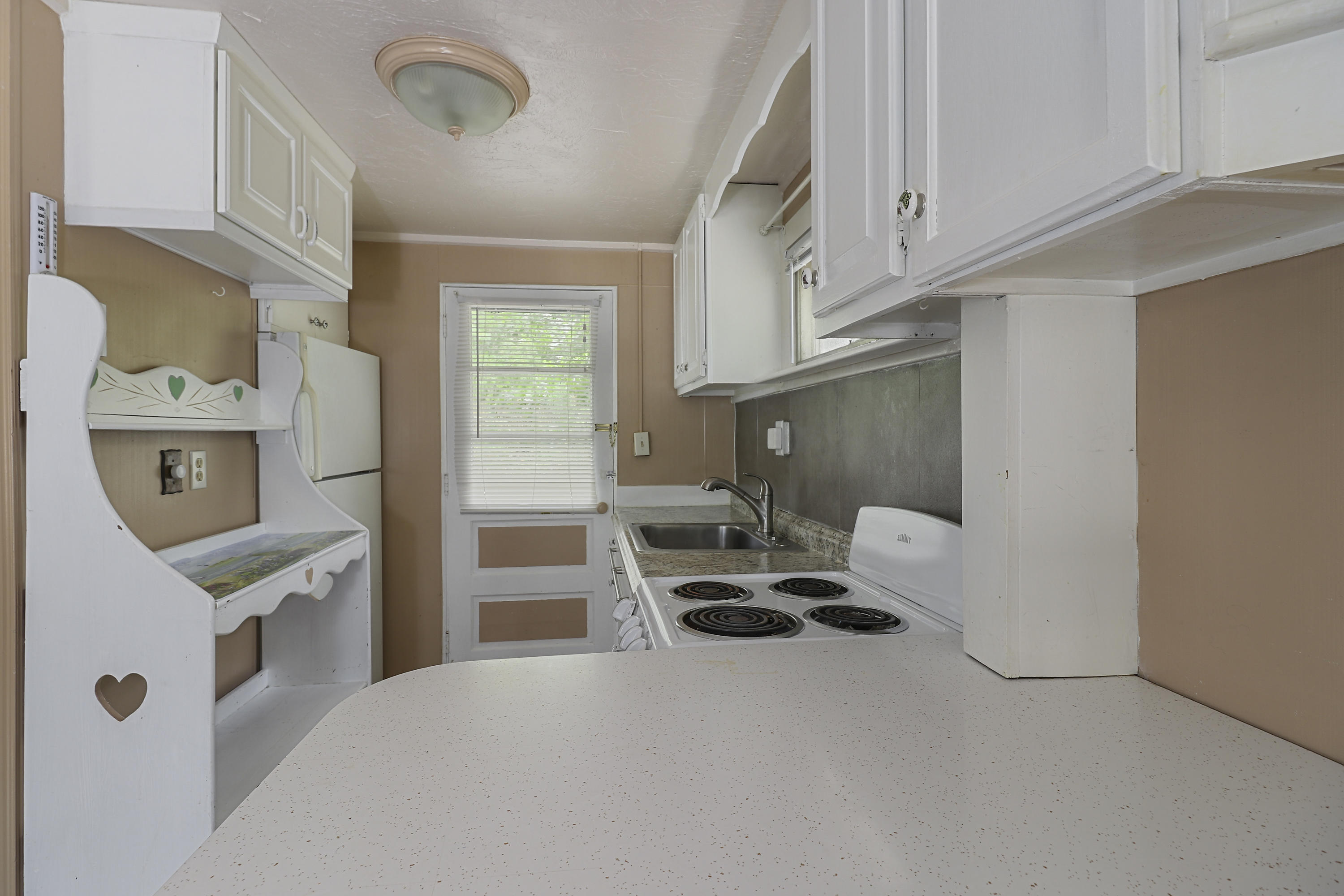 3546 Main Street, Unit 9 Brewster, MA 02631 - Photo 8 of 14 a kitchen with stainless steel appliances kitchen island granite countertop a sink a stove and a refrigerator