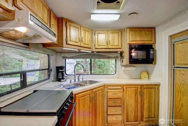 a kitchen with stainless steel appliances granite countertop a stove a sink and a microwave