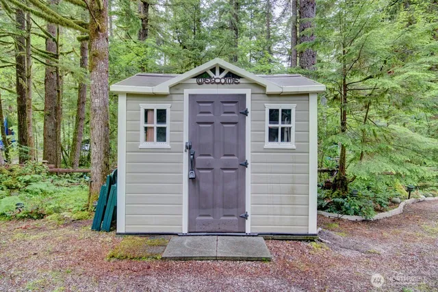 a view of a house with a garage and large trees