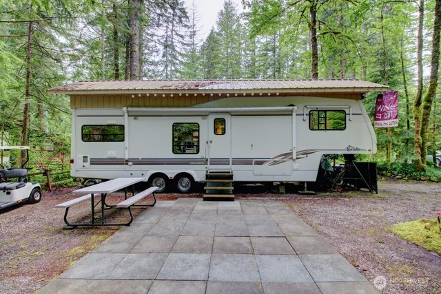 a backyard of a house with barbeque oven and outdoor seating