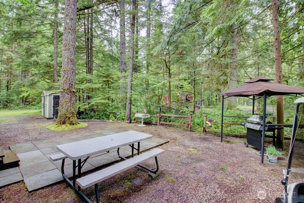 25-1 Goldrush Road Deming, WA 98244 - Photo 8 of 38 a view of a patio with furniture and table under an umbrella