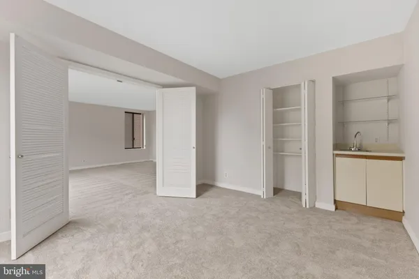 an empty room with closet and windows