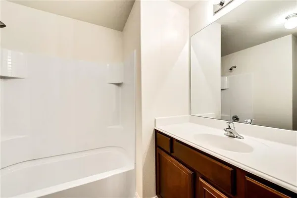a spacious bathroom with a double vanity sink a mirror and a toilet