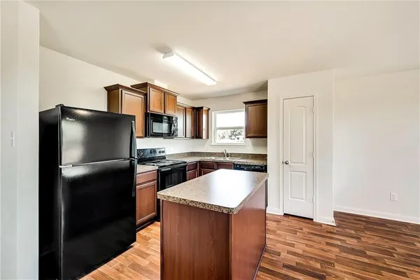 a kitchen with stainless steel appliances granite countertop a refrigerator a stove a sink and a microwave oven