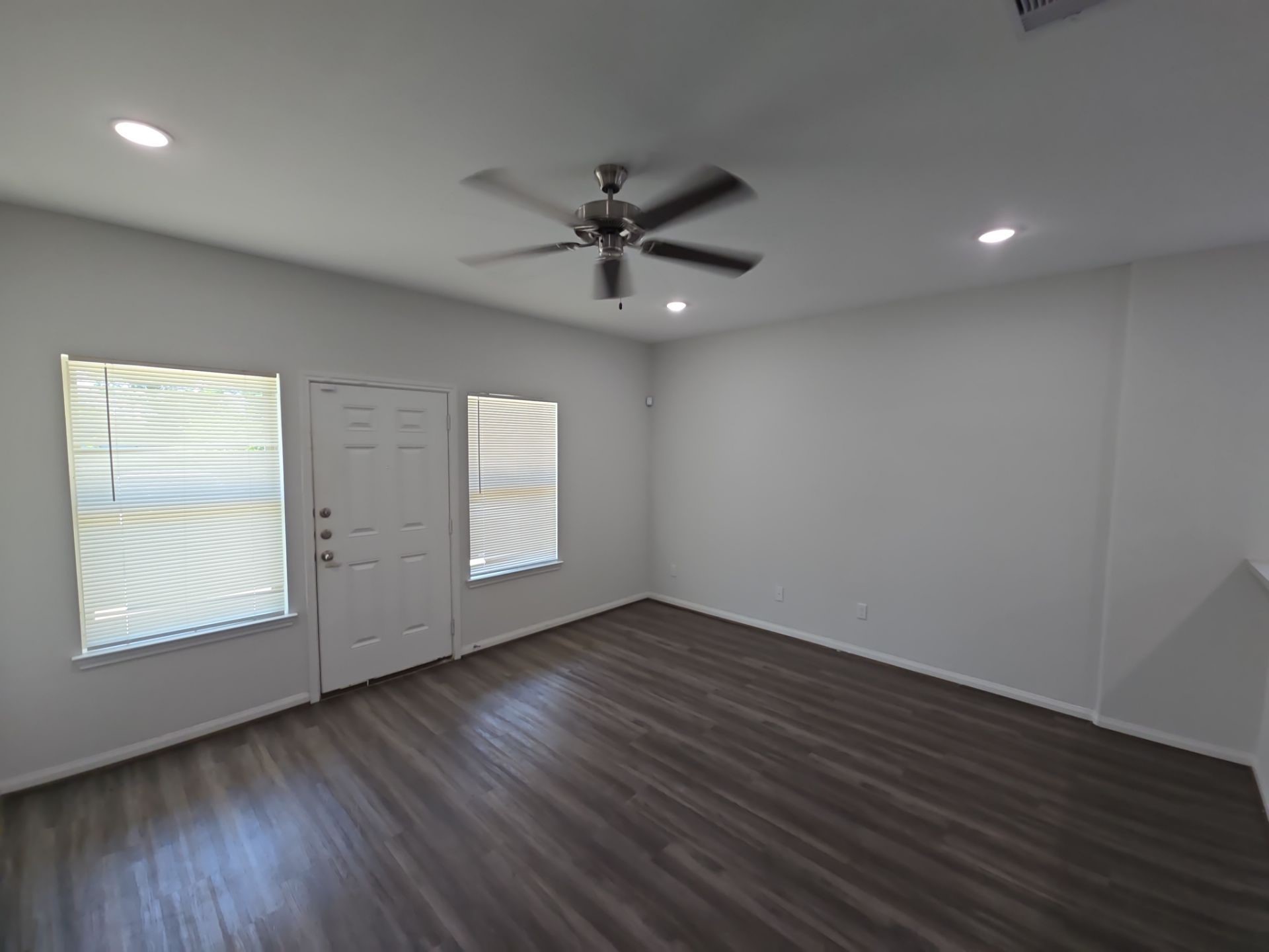 9509 Madera Road, Unit A Houston, TX 77078 - Photo 6 of 29 an empty room with wooden floor chandelier fan and windows