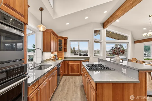 a kitchen with stainless steel appliances granite countertop sink stove top oven and refrigerator