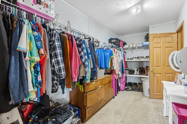 a view of walk in closet with clothes and shoes
