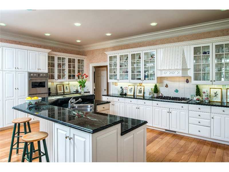 1021 Ponus Ridge Road New Canaan, CT 06840 - Photo 8 of 25 a kitchen with granite countertop a stove a sink a counter space and cabinets
