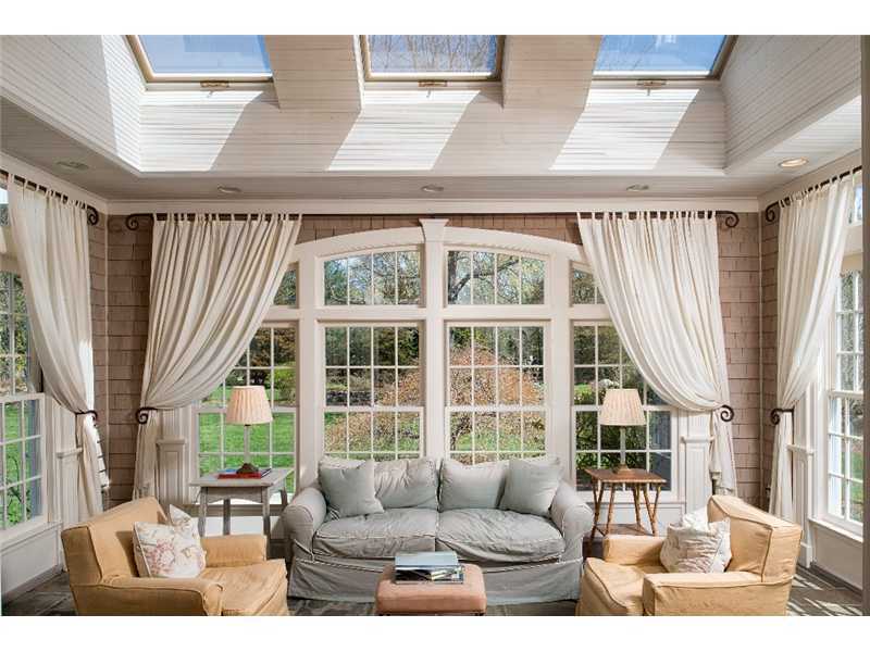 1021 Ponus Ridge Road New Canaan, CT 06840 - Photo 10 of 25 a living room with furniture a fireplace and large windows