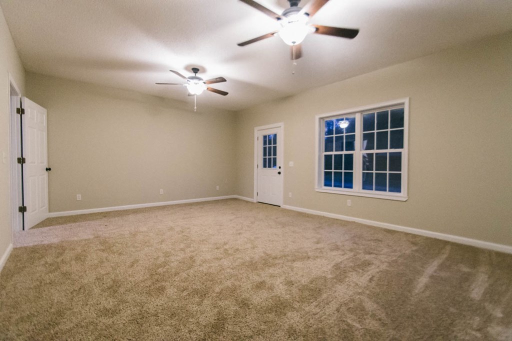 4841 Sandy Point Road Lizella, GA 31052 - Photo 15 of 42 an empty room with windows and fan