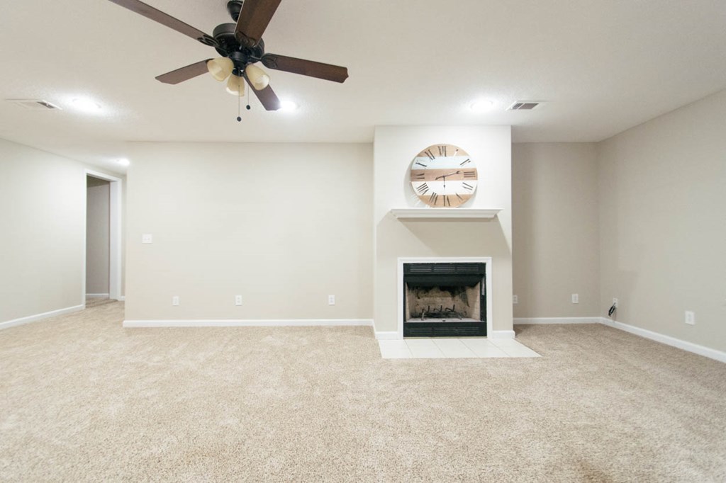 4841 Sandy Point Road Lizella, GA 31052 - Photo 24 of 42 an empty room with a fireplace and a ceiling fan
