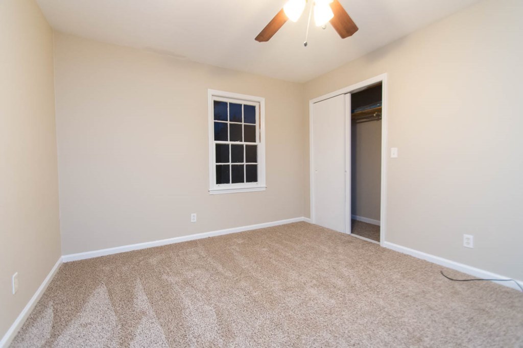 4841 Sandy Point Road Lizella, GA 31052 - Photo 30 of 42 an empty room with chandelier fan and windows