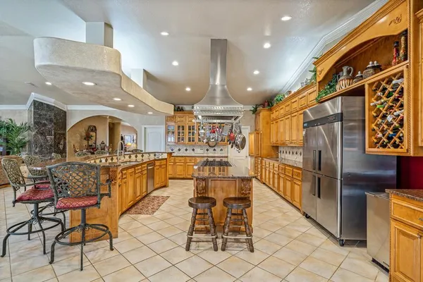 a living room with stainless steel appliances furniture a dining table and kitchen view