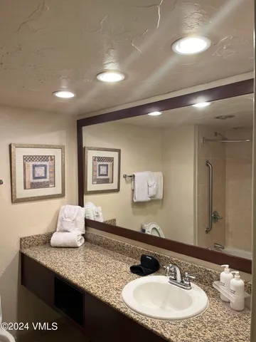 a bathroom with a granite countertop sink and a mirror
