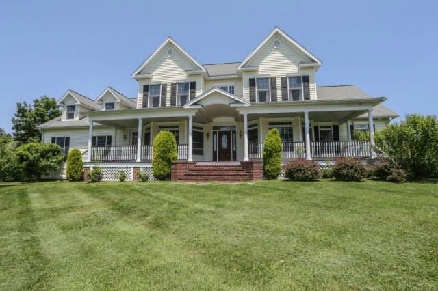 a front view of a house with a garden and trees