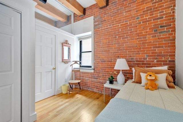 a bedroom with a bed and painting on the wall
