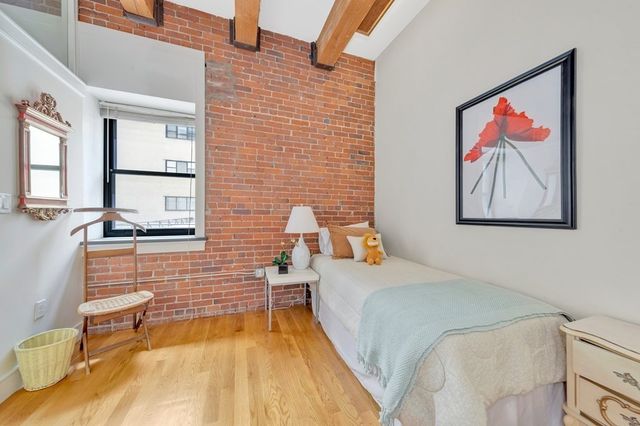 a bedroom with a bed and painting on the wall