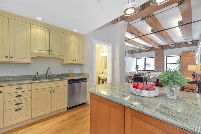 a kitchen with granite countertop white cabinets and sink