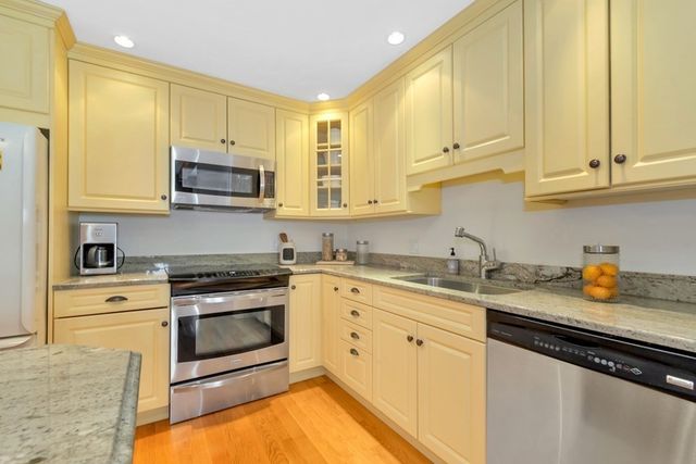 a kitchen with stainless steel appliances granite countertop a sink a stove a microwave and cabinets