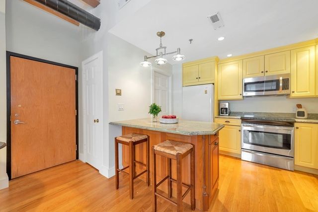 a open kitchen with stainless steel appliances granite countertop a sink and a refrigerator