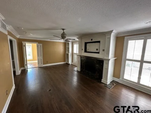 an empty room with wooden floor and fireplace