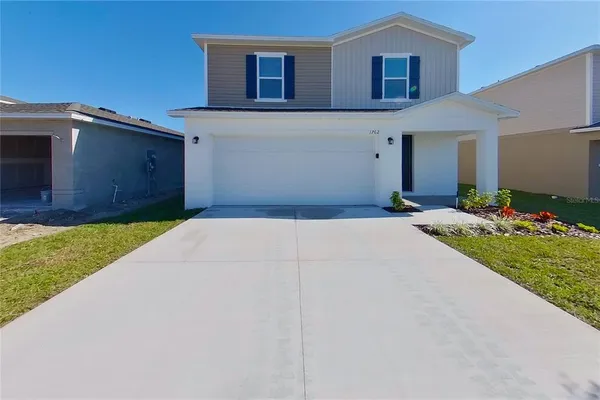 a front view of a house with a yard and garage