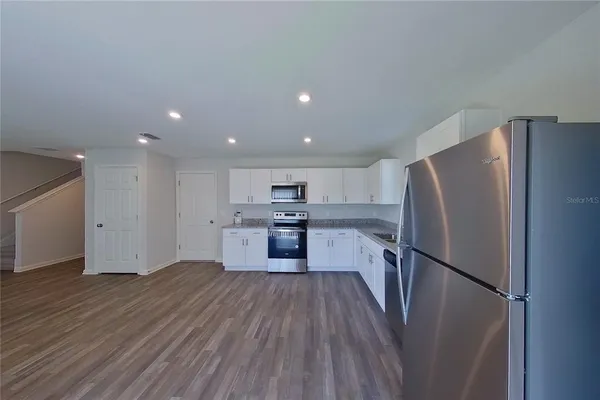 a kitchen with a refrigerator a sink and cabinets