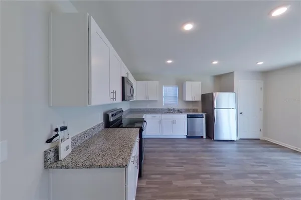 a kitchen with stainless steel appliances granite countertop a sink refrigerator and microwave