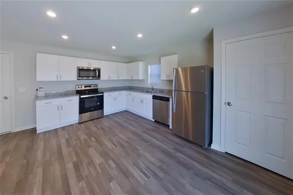 a kitchen with stainless steel appliances granite countertop a refrigerator stove and sink