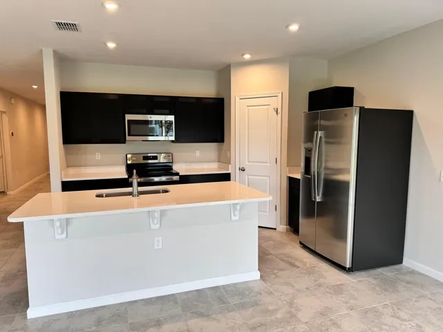 a view of a kitchen with stainless steel appliances a refrigerator and a stove