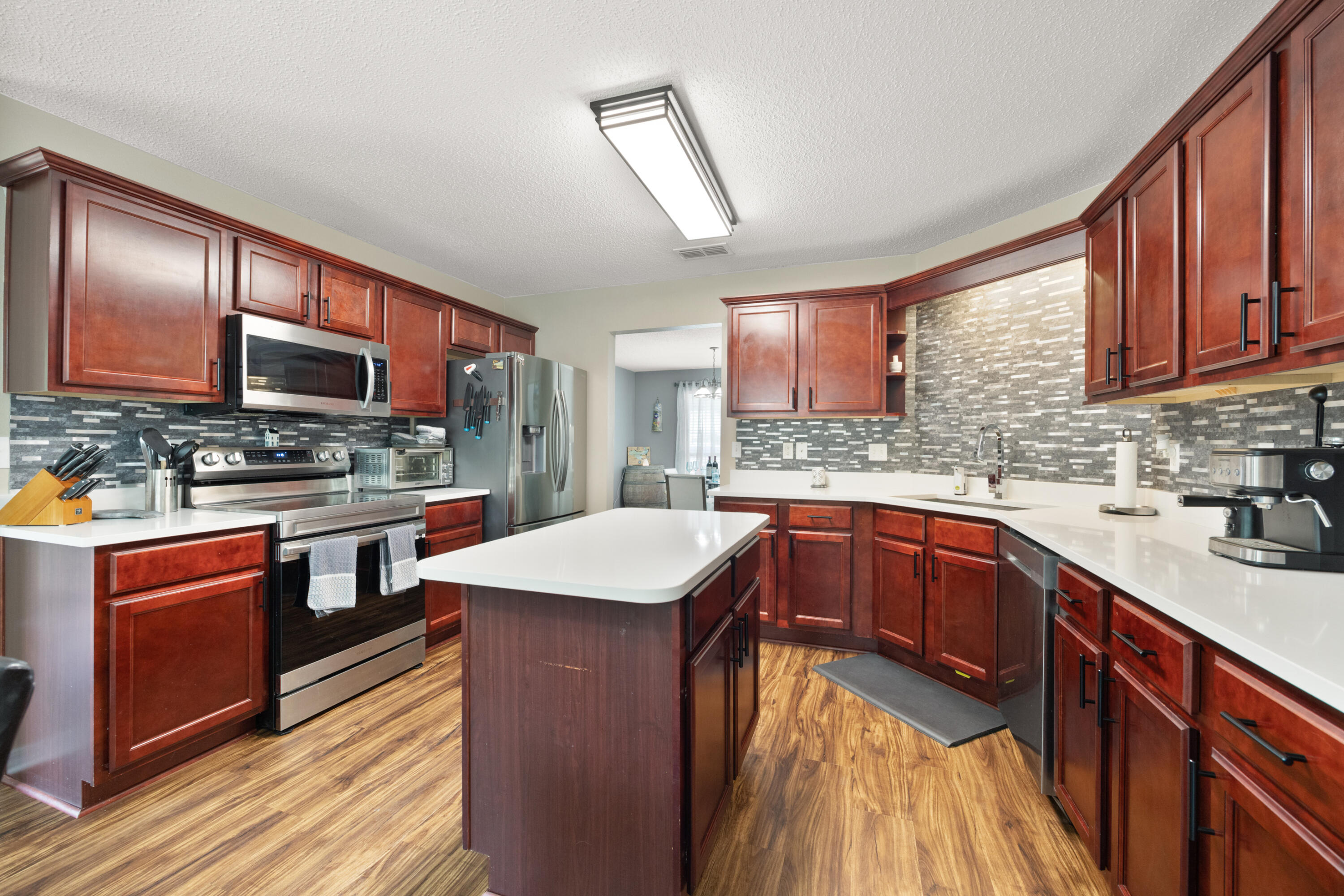 143 Sandstone Trail Crestview, FL 32539 - Photo 9 of 40 a kitchen with stainless steel appliances granite countertop wooden cabinets sink and stove top oven