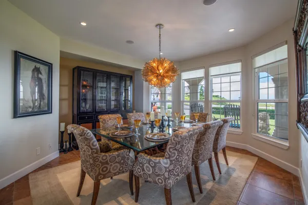 a dining room with furniture a chandelier and wooden floor