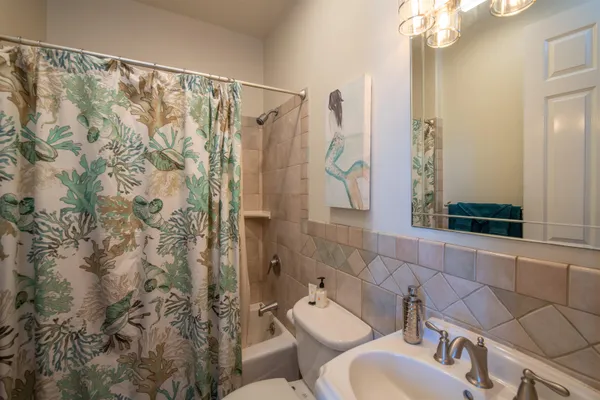 a bathroom with a toilet sink and shower curtain