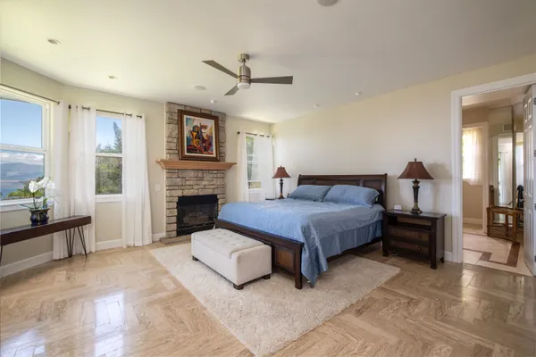 a spacious bedroom with a bed a table and painting on the wall