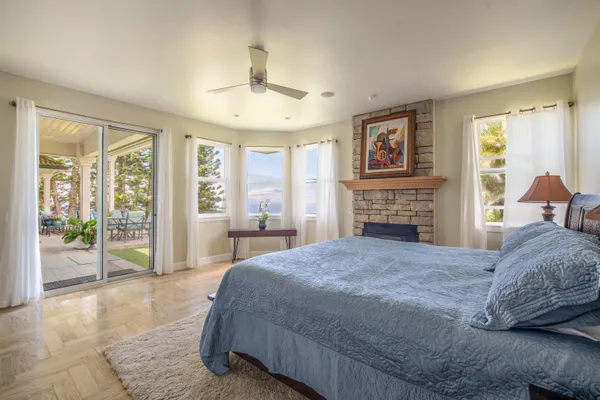 a spacious bedroom with a bed and glass windows