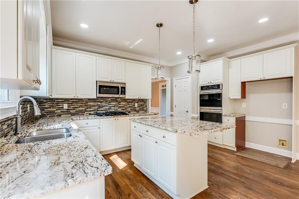 5719 Brookstone Walk Northwest Acworth, GA 30101 - Photo 13 of 54 a kitchen with stainless steel appliances granite countertop a sink stove and refrigerator
