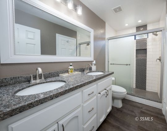 224 Richard Court Ridgecrest, CA 93555 - Photo 18 of 49 a bathroom with a granite countertop double vanity sink a mirror and a toilet