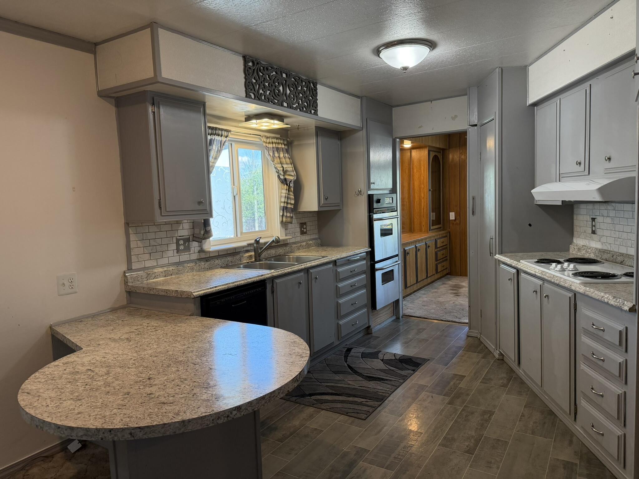 301 Freeman Road, Unit 70 Central Point, OR 97502 - Photo 24 of 39 a kitchen with kitchen island granite countertop a sink cabinets and stainless steel appliances