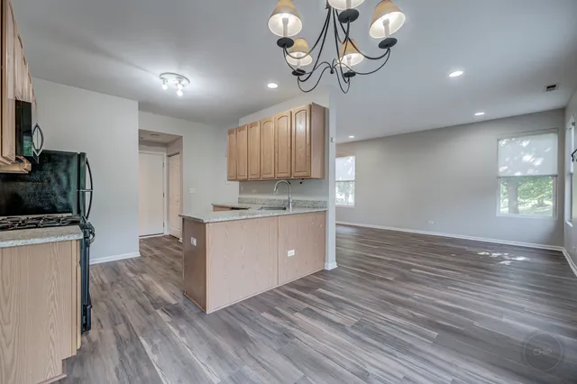 a large kitchen with stainless steel appliances granite countertop a white cabinets stove a sink and dishwasher