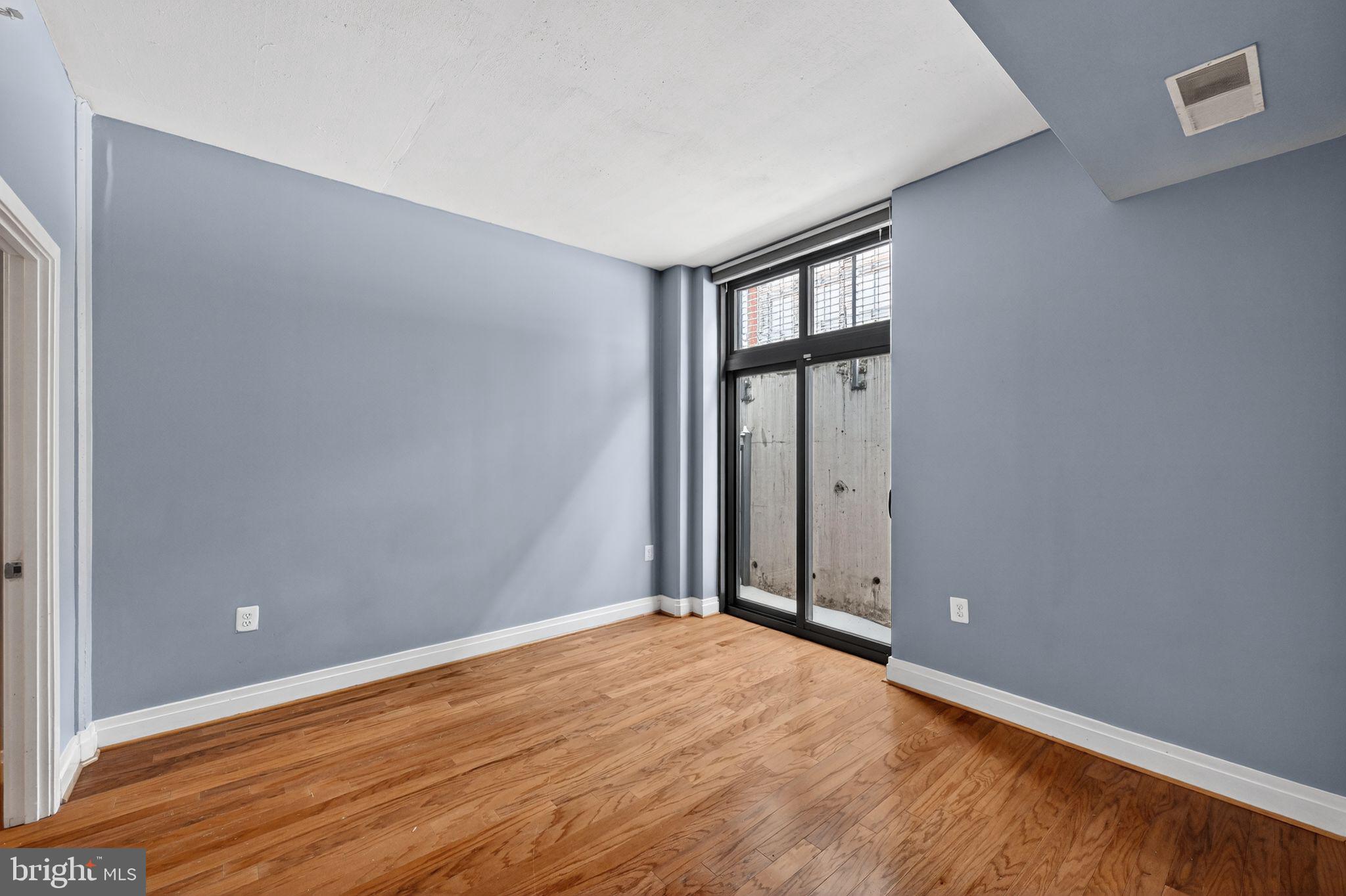 2120 Vermont Avenue Northwest, Unit 4 Washington, DC 20001 - Photo 11 of 24 an empty room with wooden floor and windows