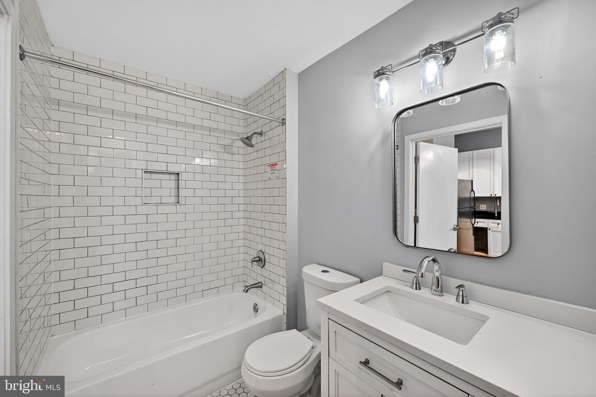 2120 Vermont Avenue Northwest, Unit 4 Washington, DC 20001 - Photo 15 of 24 a bathroom with a bathtub shower sink mirror and toilet