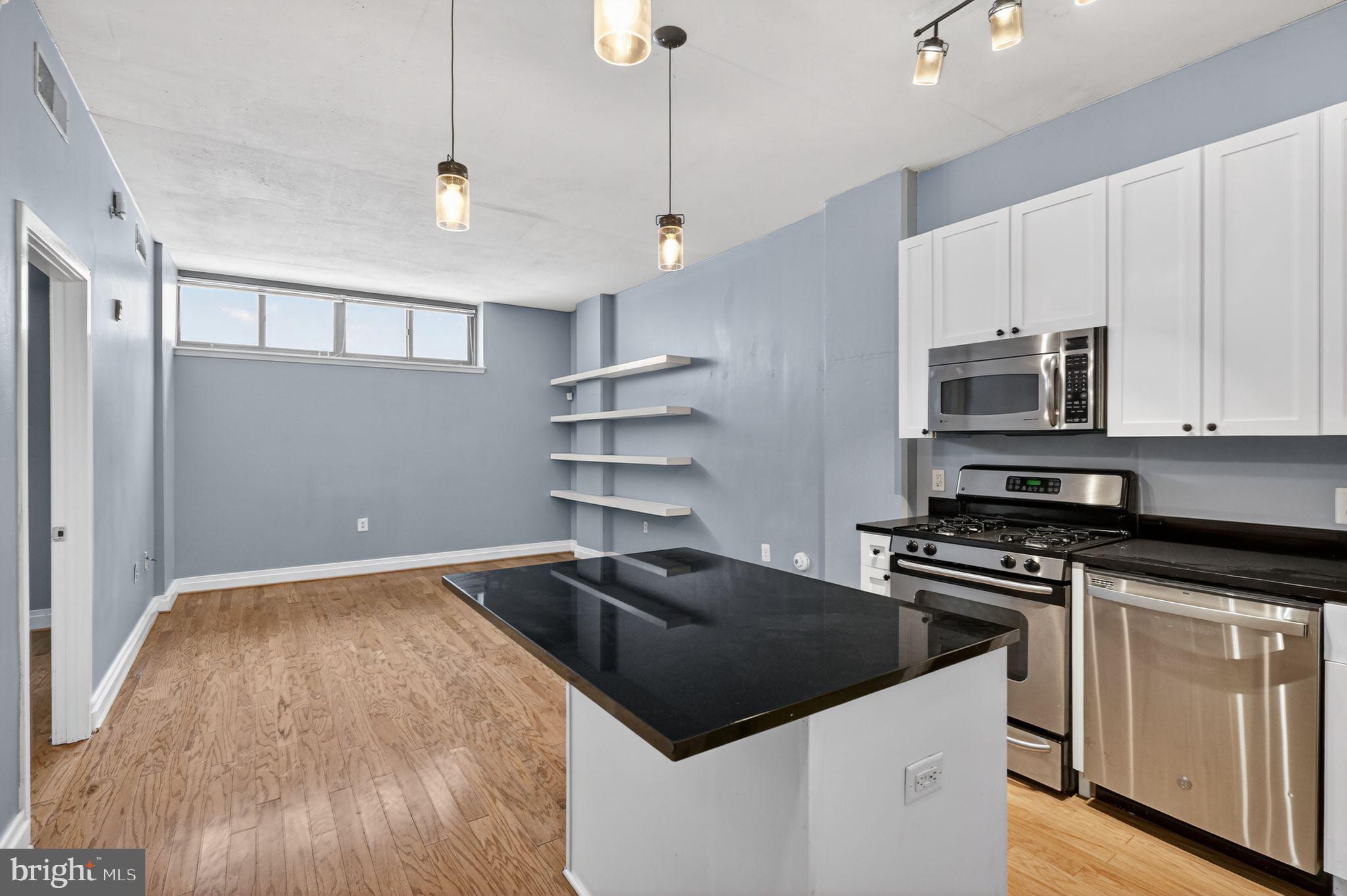 2120 Vermont Avenue Northwest, Unit 4 Washington, DC 20001 - Photo 6 of 24 a kitchen with kitchen island a counter space a sink and stainless steel appliances