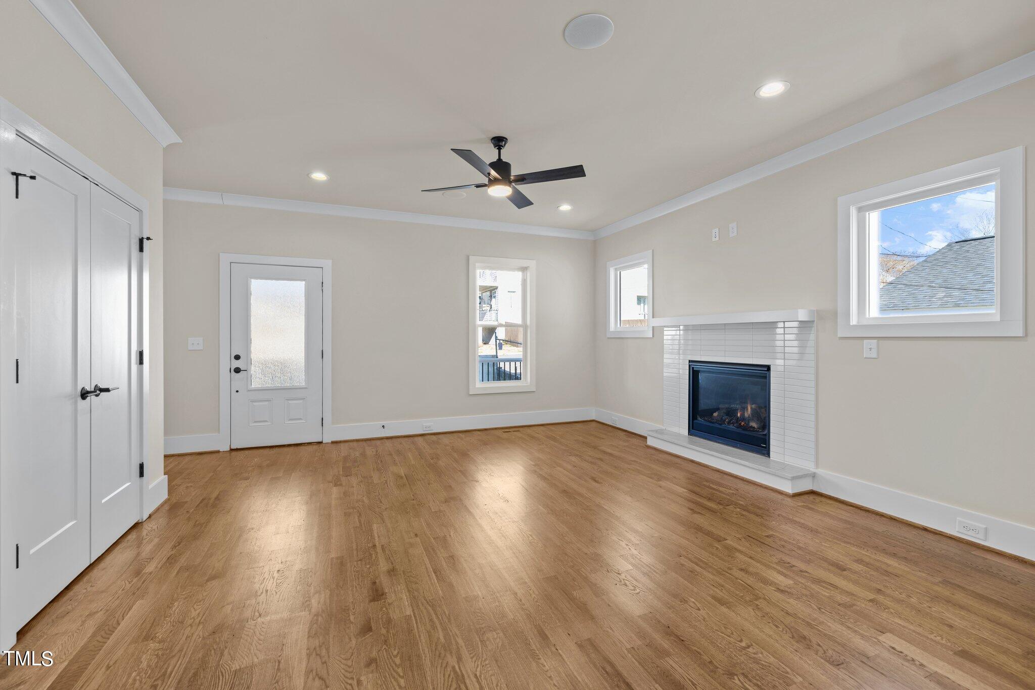 600 Bragg Street Raleigh, NC 27610 - Photo 25 of 68 an empty room with wooden floor fireplace and windows
