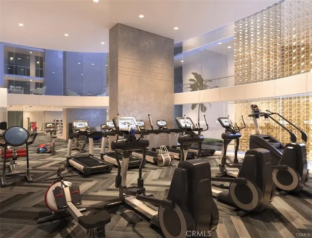a room with gym equipment and wooden floor