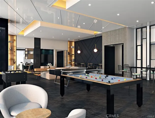 a dining hall with couches a flat tv screen and couches