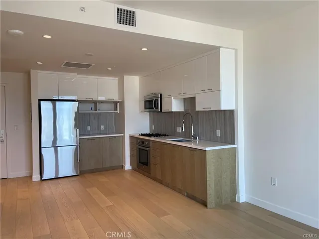 a kitchen with stainless steel appliances a refrigerator sink and microwave