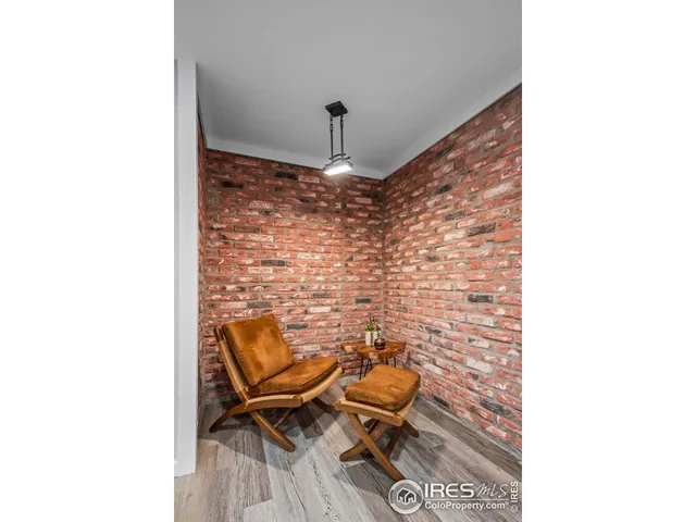 a brick room with a chair and a rug