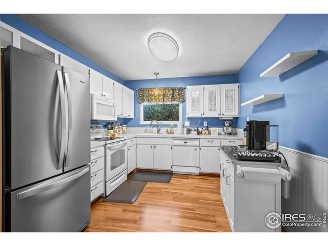 a kitchen with white cabinets and white appliances