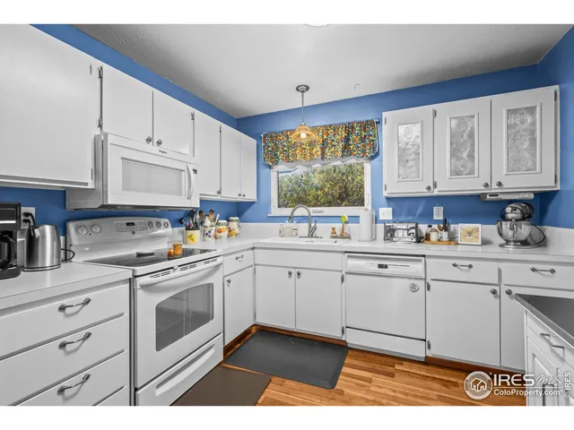 a kitchen with granite countertop white cabinets and white appliances