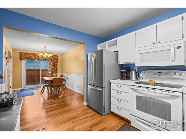 a kitchen with stainless steel appliances a stove a refrigerator a dining table and chairs